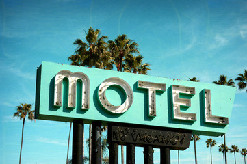 aged and worn vintage photo of old neon motel sign with palm trees - obrazy, fototapety, plakaty
