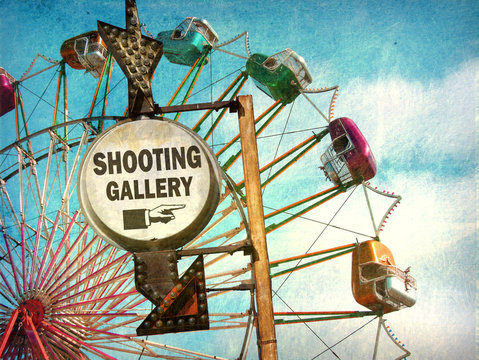 aged and worn vintage photo of shooting gallery sign at carnival