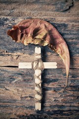 Vintage cross with dried leaves
