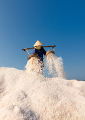 Women collecting salt from the farm in traditional industry practice in Hon Khoi, Nha Trang, Vietnam