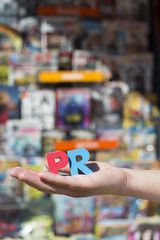 Women hold wooden letters PR