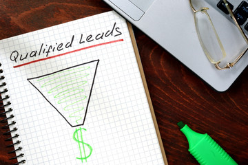 Qualified Leads  written on notebook with charts.