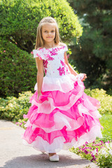 Fototapeta premium Girl in a magnificent dress walks in the garden