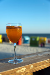 cold aperotif with blurred strandkorb beach chairs and ocean in background