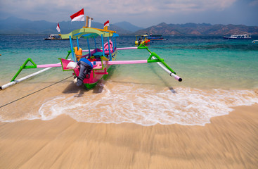 Colorful Indonesian boat at tropical sand beach in sunny day