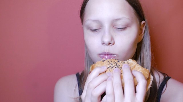 Teen girl eating a burger
