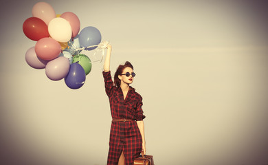 girl with multicolored balloons and bag