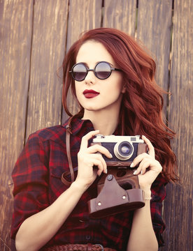 girl in plaid dress with camera and sunglasses