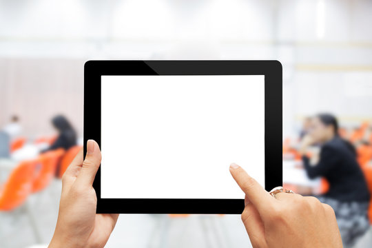 Close-up hand using digital tablet with blank screen against blurred people in business meeting
