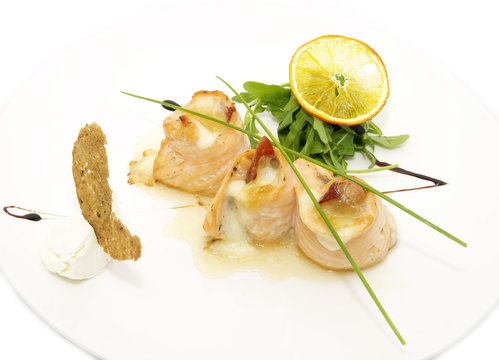 fried fish rolls with herbs and vegetables on white background