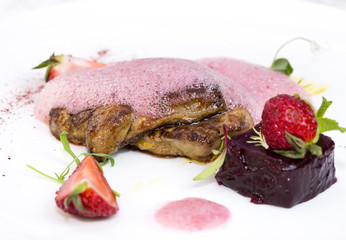 Roast goose liver is decorated with greens and strawberries