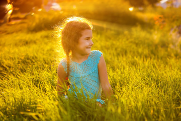 baby girl sitting in the grass at sunset summer smiling childhoo