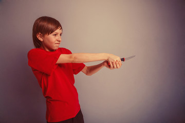 Teenager boy twelve years in the red t-shirt with knife evil Bon