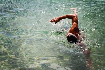 Strong muscular man swimming in the sea ocean scrawl style. Active summer holiday vacation. Sport,...