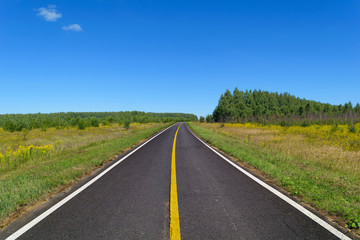 Fototapeta na wymiar Country asphalt highway with one line of yellow and two line of solid white road markings