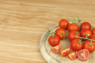 Fresh tomatoes on the kitchen table. Tomatoes on a wooden cutting board. Domestic cultivation of vegetables. Fresh organic food ready to cook. Fresh dietary ingredients. Raw vegetables to raw food.
