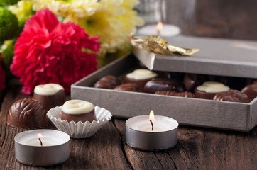 Fototapeta na wymiar chocolate candy, candles and flowers