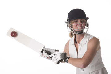 Woman hitting cricket ball with a bat