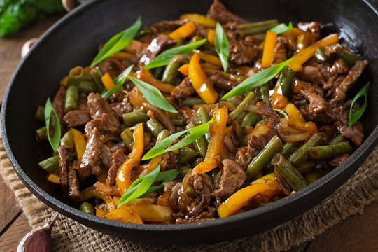 Stir frying beef with sweet peppers and green beans