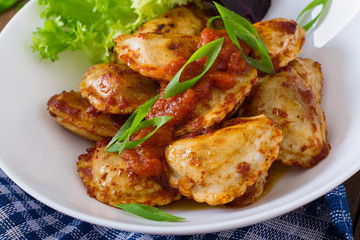 Delicious ravioli with tomato sauce and green onions