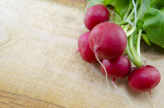 Raw radishes on a wooden board