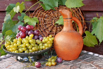 Grapes with wine jug on table 
