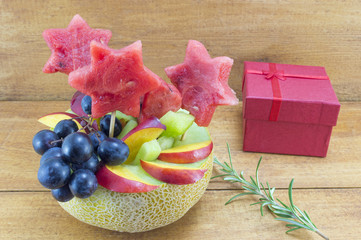 Healthy attractive fruit salad served in a fresh melon next to a