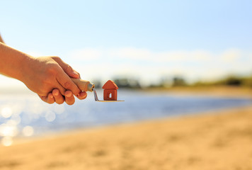 build own house. house in the children's hands against the background of the sun-drenched coast