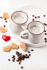Tow cup of cappuccino with cookies as hearts