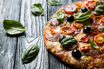 Pizza with salami, olives and basil