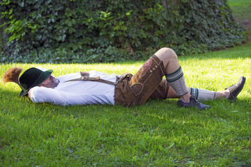 bavarian man sleeping on the grass