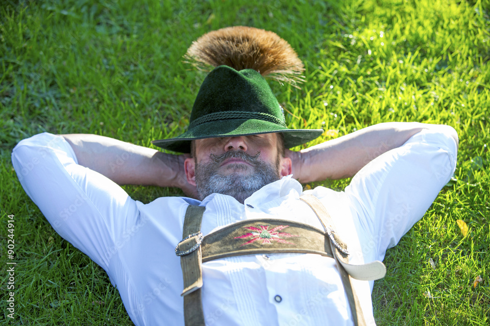 Wall mural bavarian man sleeping on the grass