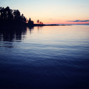 Wild nature of Russian North. Sunset. Lake and trees.