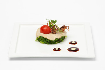 Dish of vegetables on white square plate.