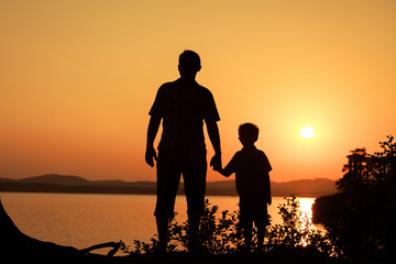 Fototapeta na wymiar father and son playing on the coast of lake