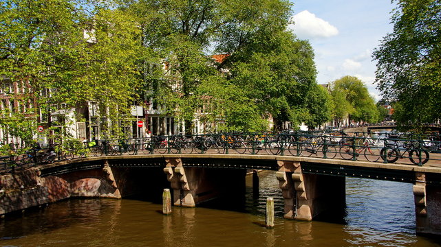 romantische Brücke mit vielen Fahrrädern  über Gracht in Amsterdam