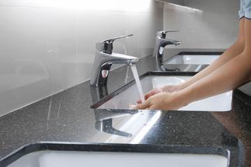 white washbasin and faucet on granite counter with hand washing