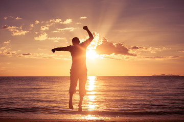 Fototapeta premium Man with his hands up on the beach