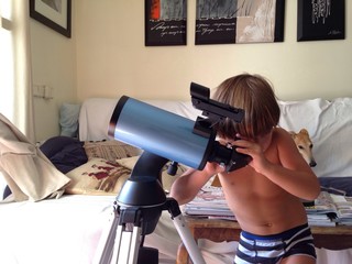 niño mirando las estrellas con telescopio