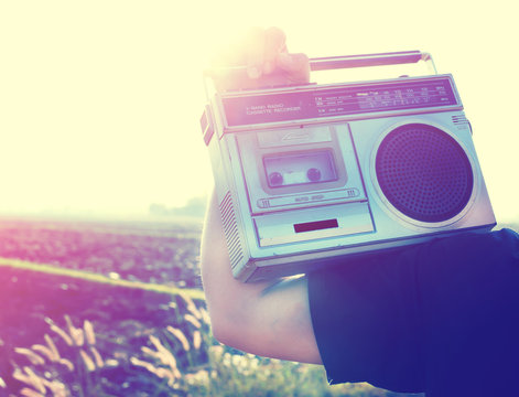Man hand holding vintage radio on nature background