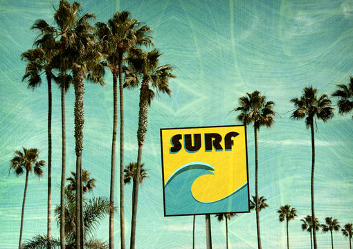 aged and worn vintage photo of retro graphic surf sign on beach