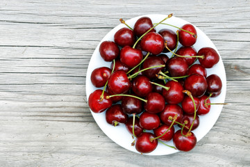 Kirschen auf einem Teller - Holzbrett 
