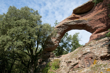 Fototapeta na wymiar La roca foradada de Prades Stone Bridge red made by natural erosion of the stone from the mountains of Montsant, Prades, Catalonia, Spain