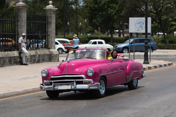 Kuba el Malecon in Havanna auf der Strasse fahrender amerikansicher pinker Cabriolet Oldtimer