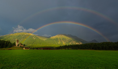 Real full double rainbow in a mountain meadow