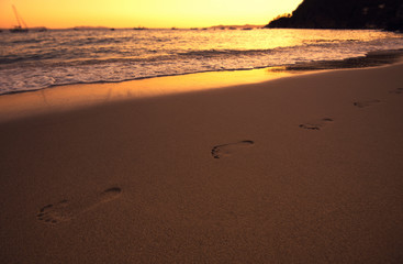 Empreinte de pas sur le sable au bord de l'eau