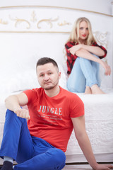 Obraz premium woman and a man in a quarrel sitting on the bed