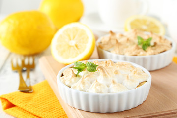 Lemon meringue pie in bowl on white wooden background