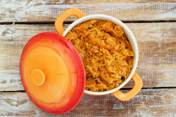 Polish bigos in saucepan on rustic wooden surface

