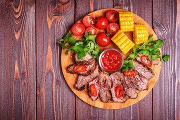 BBQ lamb steak with vegetable and herb on dark wooden background